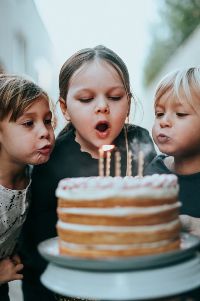 three-children-blowing-out-candles